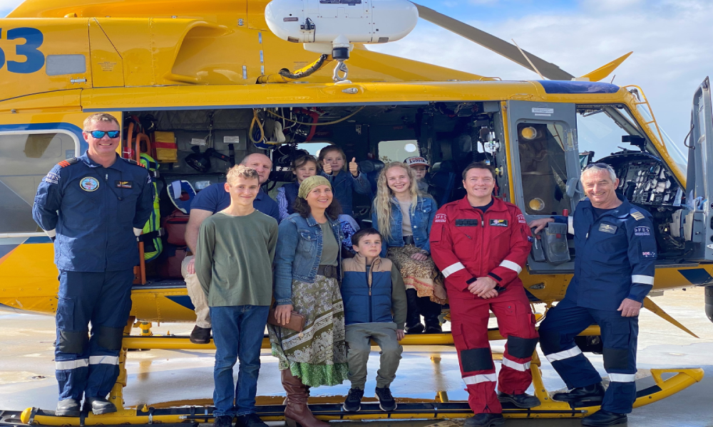 Rescued patient and his family lean inside the RAC Rescue Helicopter with the crew who saved Sebastian's life
