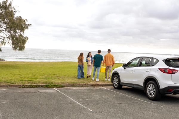 Group of friends walking towards beach from car park