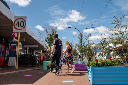 Man and woman walking their dog through pedestrian only zone