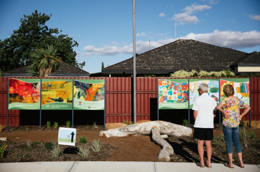 Community members looking at new outdoor art gallery