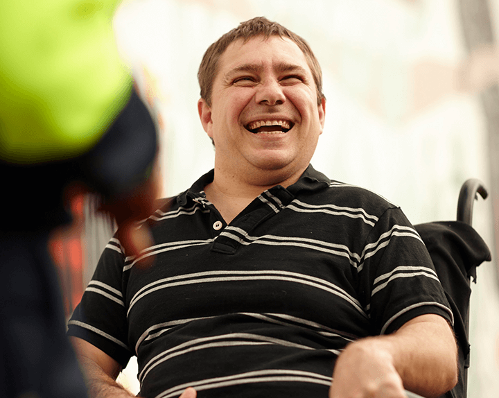 Man smiling using wheelchair