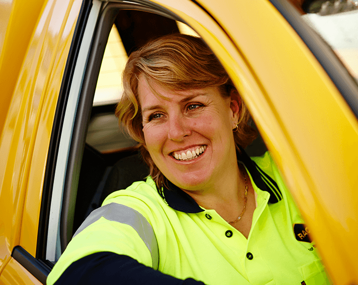 Woman smiling wearing RAC uniform driving patrol car