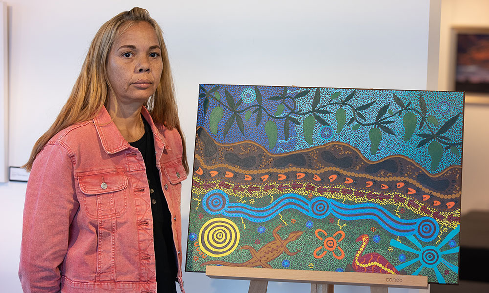 Yamatji Noongar artist Godfrena Gilla with her artwork titled 'My Land'.