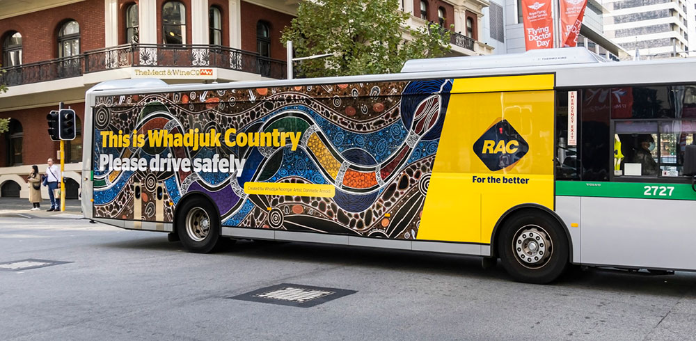 Artwork by Whadjuk Noongar artist Dannielle Arnold titled 'Bilya Nyitting' is featured across a Transperth bus, with an RAC Road Safety message.