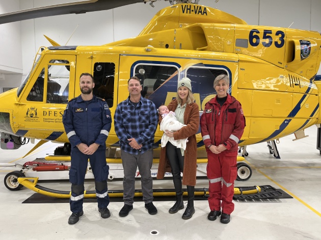 RAC Rescue Aircrew Officer Jon Stewert-Dawkins, Greg, Cam, Ocea and RAC Rescue Critical Care Paramedic Madelyn Coertzen are standing together in front of the RAC rescue helicopter.