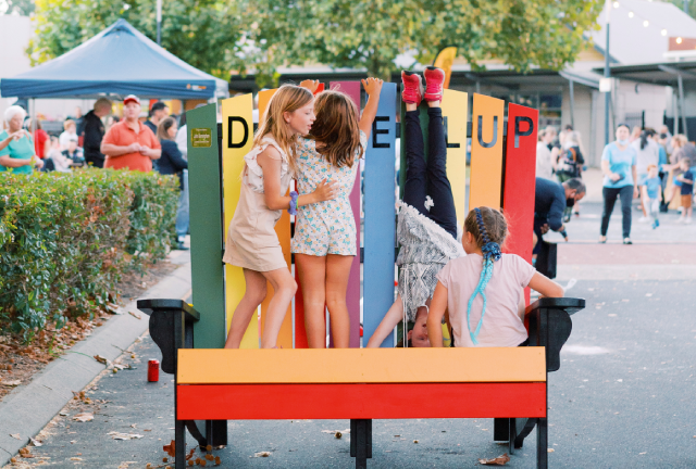 Children are playing on a large colourful beach chair, that was built as part of the RAC Dalyellup Street Party