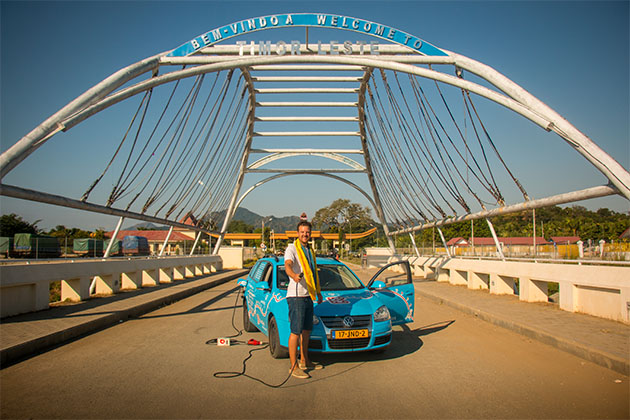 Plug Me In project founder Wiebe Wakker holding an EV plug on a Timor-Leste traffic bridge