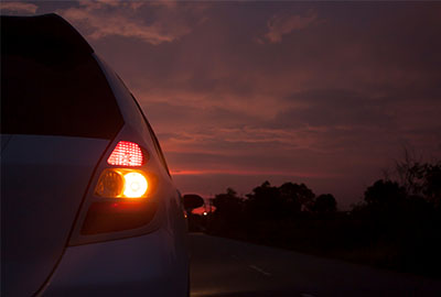 A car indicating on a road at night