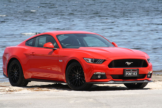 Red Ford Mustang parked on the beach