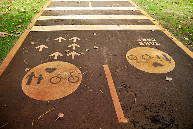 'Take care' painted on a cycle path to remind pedestrians and cyclists to pay attention