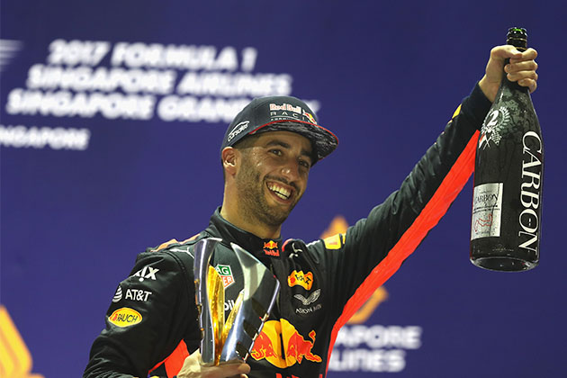 Daniel Ricciardo holding a bottle of champagne after a victory