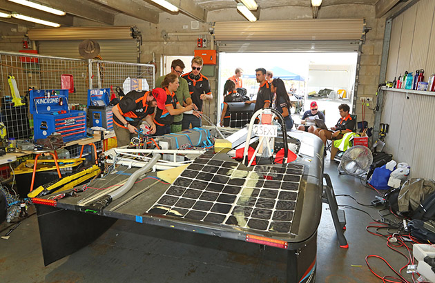 Australian team members prepare in the pit garage