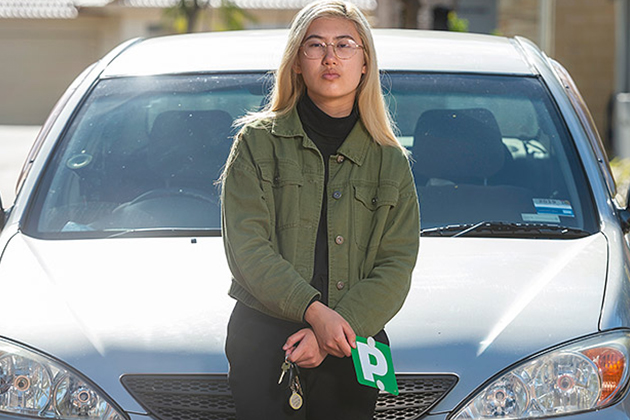 Image of Megan Ogle in front of her car