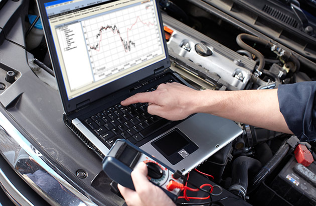 Mechanic in a workshop works on a computer 