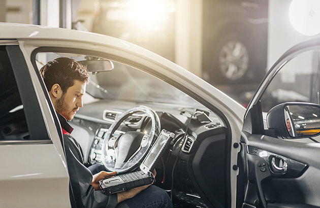 Mechanic working on car computer system