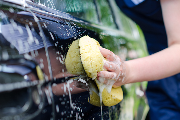 Image of person washing car with sponge