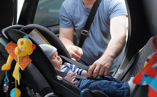 Child being strapped into a car seat