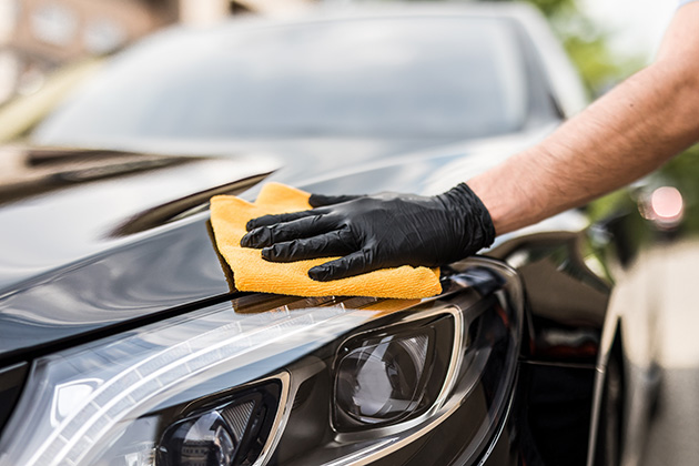 Person waxing a black car