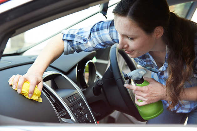 Woman spraying car dashboard