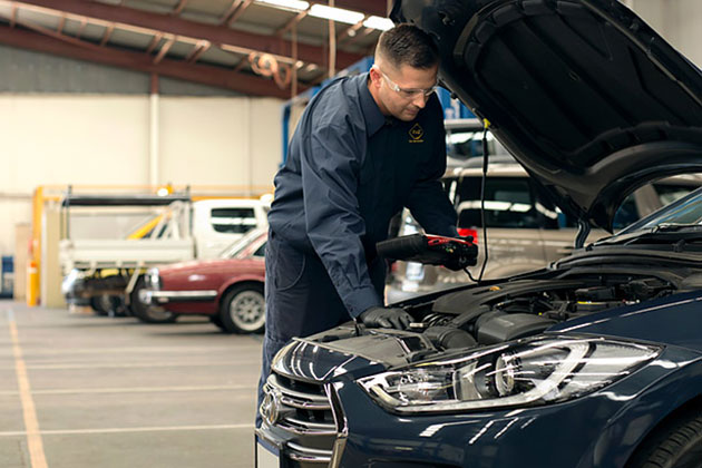 Mechanic looking under the bonnet of a car