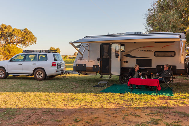 A couple sitting outside a caravan