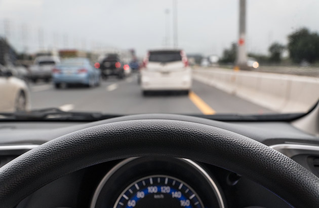 View from behind car steering wheel