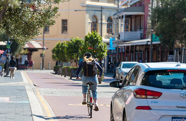 Cyclist riding alongside a car