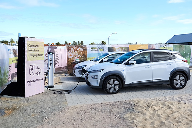 Two electric cars plugged into a charger