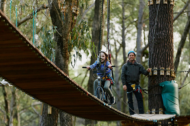 Child riding a bike on a zipline