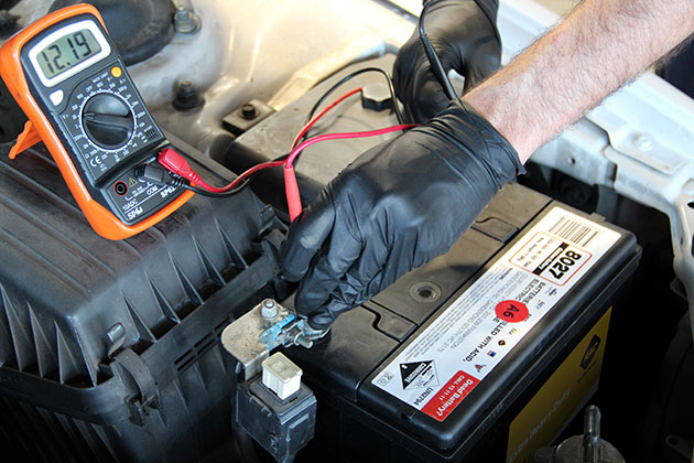 Mechanic checking car battery charge