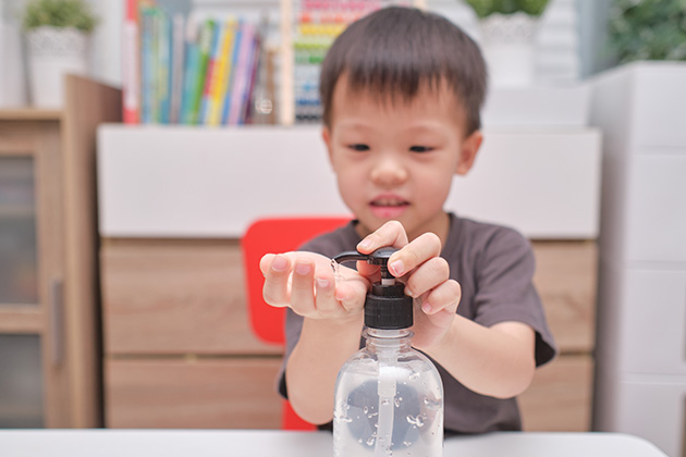 Kid using hand sanitiser