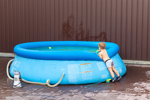 Kid leaning against pop-up pool