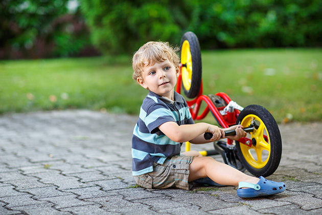 Toddler with bike on driveway