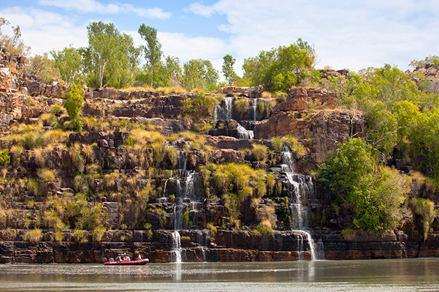 Boat beneath a waterfall