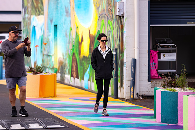 Woman walking down a colourful laneway
