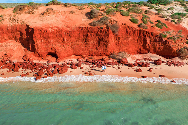 People standing in front of red cliffs