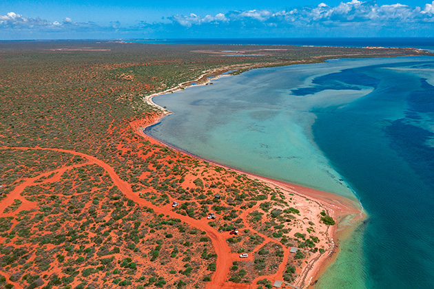 Aerial of red cliffs and water