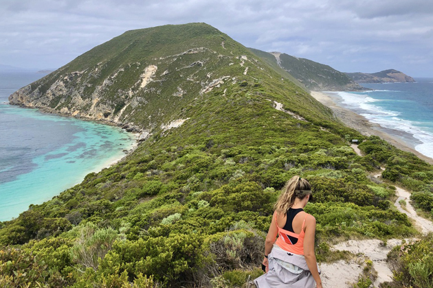 a woman walking along the hiking trail of bald head