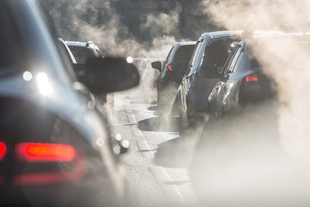 Cars stuck in traffic surrounded by haze of tailpipe emissions