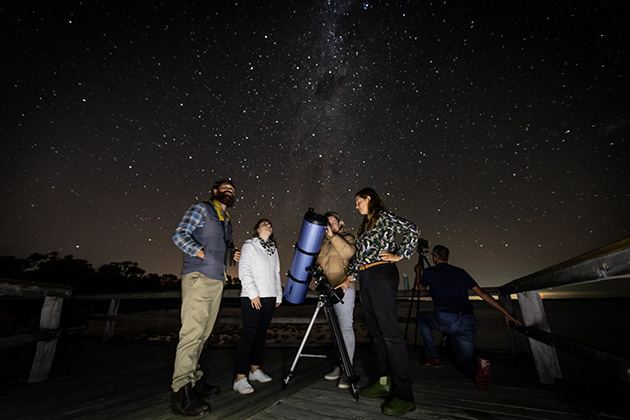 Group of people looking into telescope