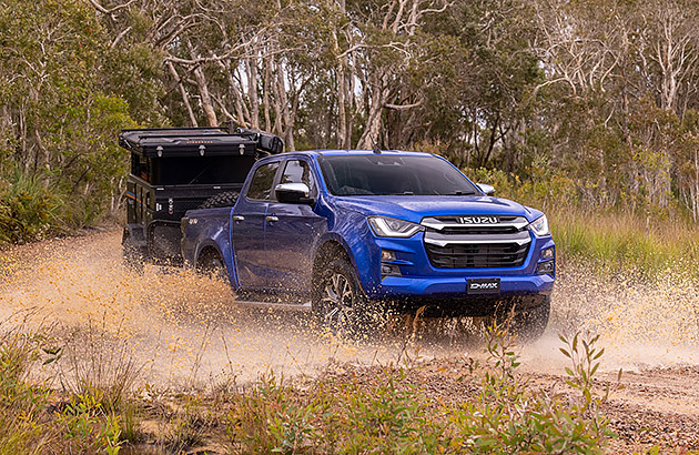 A blue Isuzu D-Max pulling a trailer on a bush track