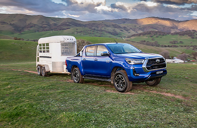A blue Toyota Hilux towing a horse float