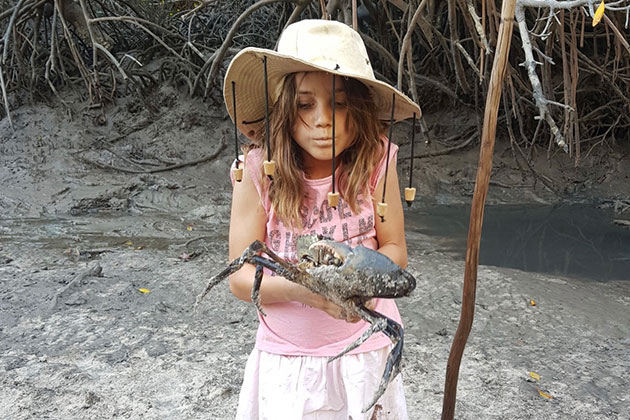 Young girl holding a crab
