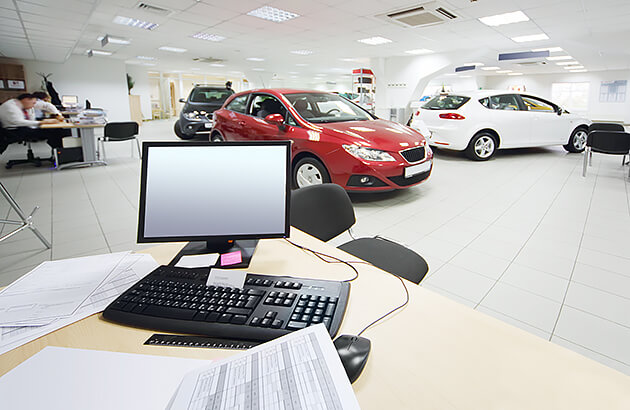 A car dealership showroom with people browsing cars