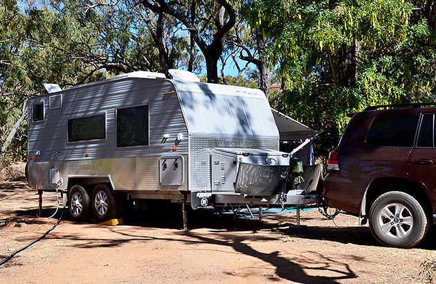 A car reversing a caravan into a caravan site