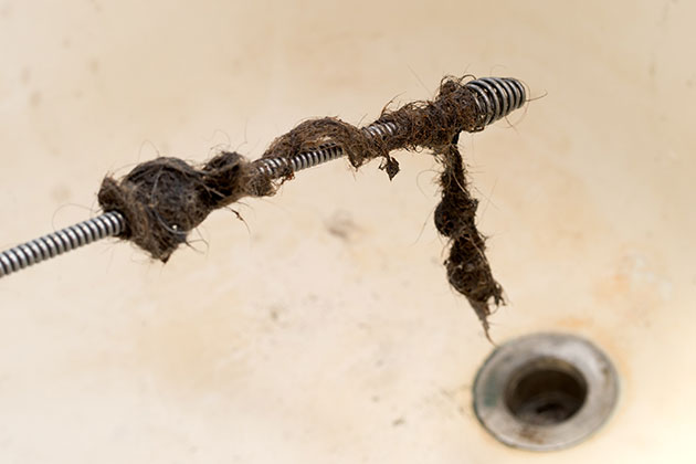 Drain auger dig out hair from sink