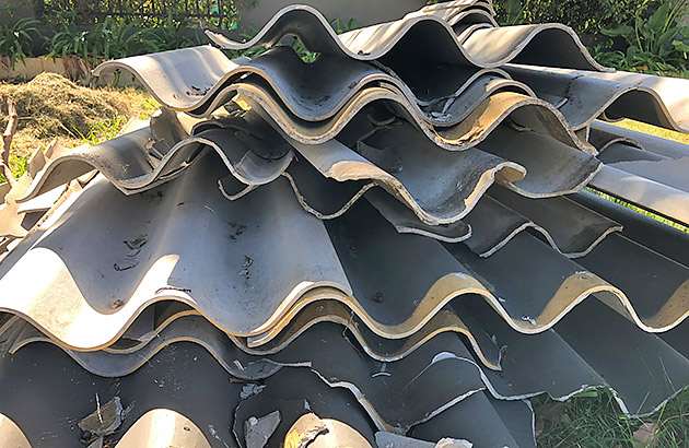 Pieces of a damaged Super Six fence stacked on the ground