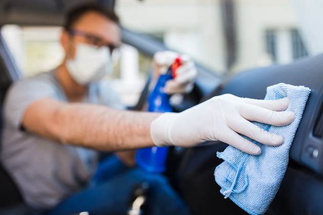 Man cleaning car with gloves and a mask