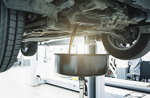 Removing old engine oil from a car in a workshop