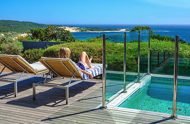 Two people on sunlounges near a pool at Injidup Spa Retreat in Yallingup